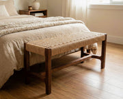 Wooden bench with woven seat in a bedroom setting
